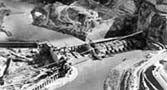East side cofferdam on left with diversion channel center and Grand Coulee Dam foundation taking shape center.