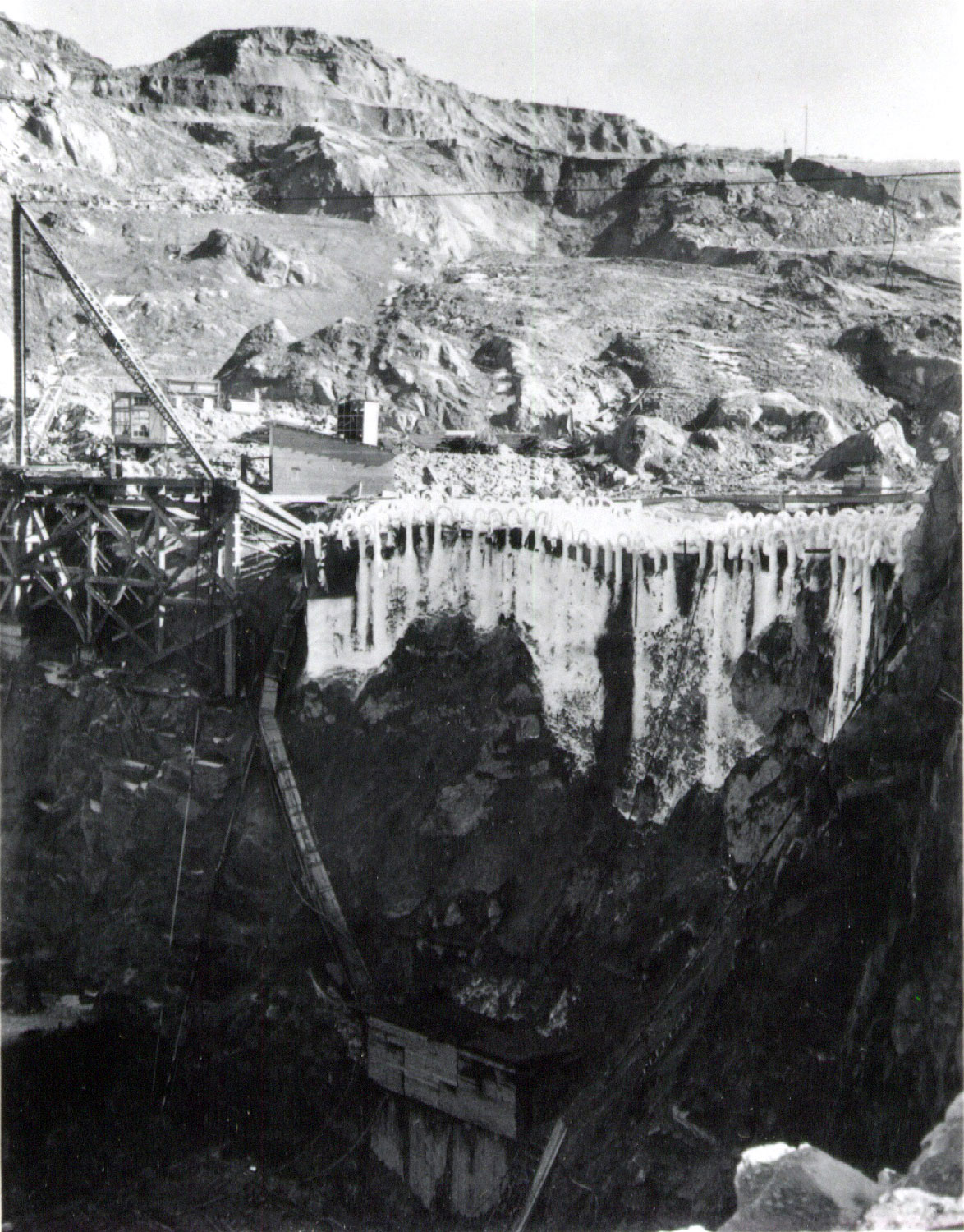 The soil around the dam site is heavy clay — mudslides are an ongoing problem. Winter rains in 1937 loosen a hillside on the east side of the river. MWAK engineers decide to freeze a portion of the hill to keep it in place. Workers drive 100 two-inch pipes into the clay and fill them with super-cooled salt brine.
