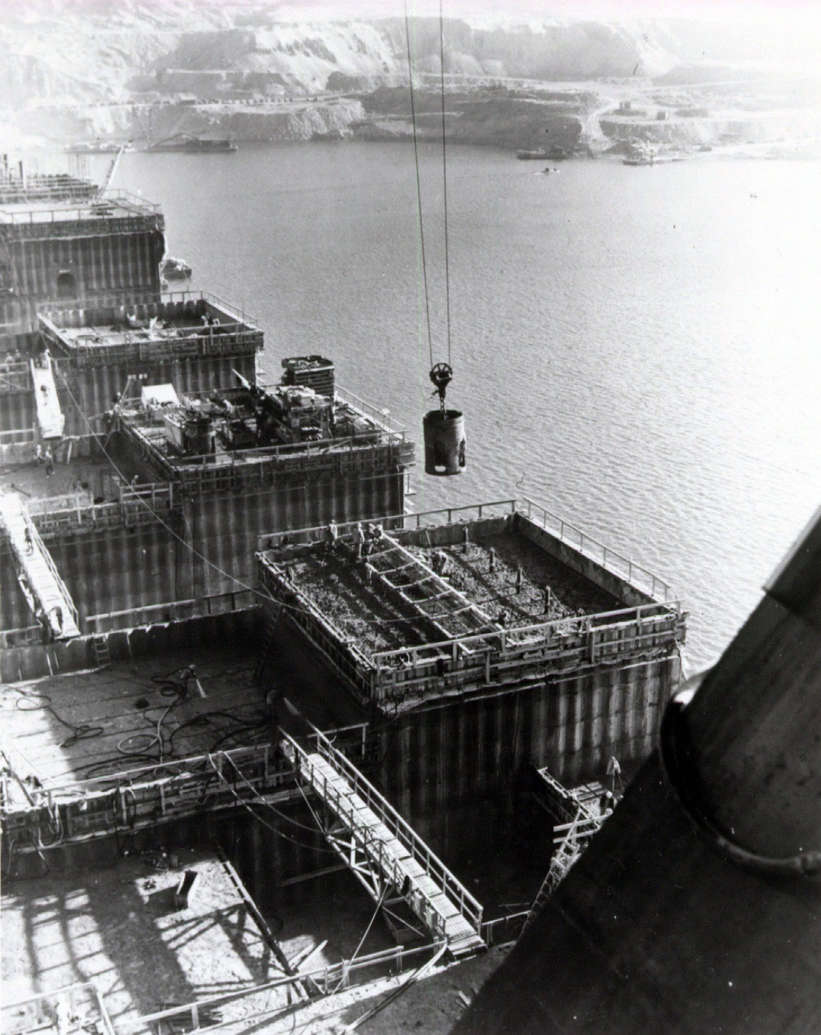 Concrete is poured in blocks which are five feet deep and 50 feet square. Over 20,000 interlocking blocks will be used to build up the dam.