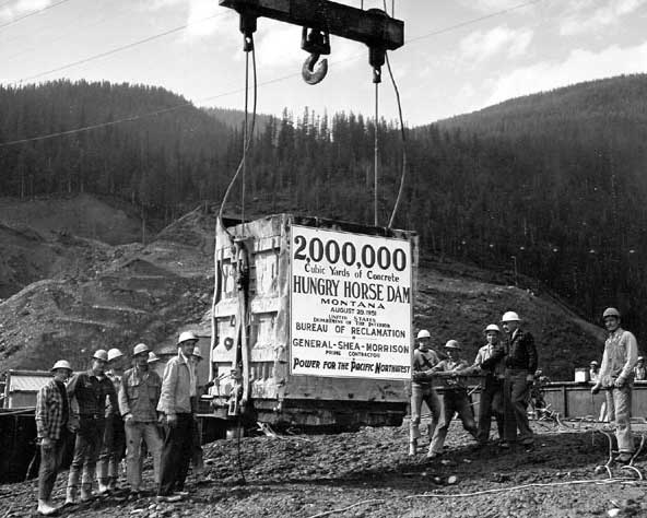 Although the two-millionth yard of concrete in Hungry Horse Dam was actually placed several hours earlier, a sign noting the occasion is hung on one of the highline buckets during a pour in Block 18A to elevation 3365. Other than the taking of photographs for public information releases, no special ceremonies were held for the event. August 28, 1951.