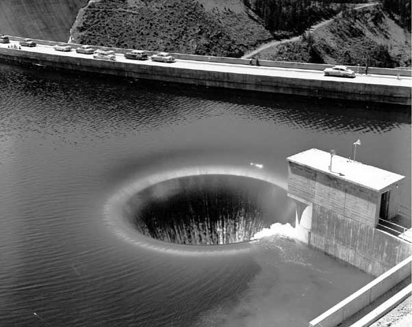 View of Hungry Horse Dam glory hole spillway, passing 30,000 cubic feet of water per second -- about 225,000 gallons per second. August 7, 1953.