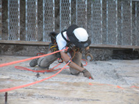 Held by ropes on the dam face