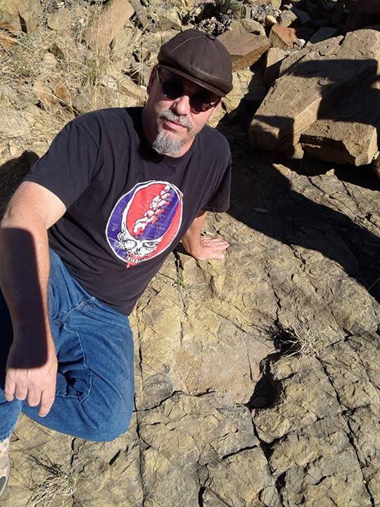 Mark Hungerford next to Hadrosaurs dinosaur footprints