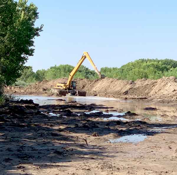 An amphibious excavator is used to move dirt and assist the Rio Grande in traveling down a new path to Elephant Butte Reservoir during construction by the Albuquerque Area Office's Socorro construction crew.