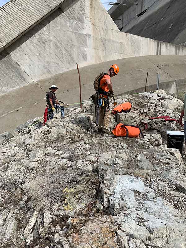 Reece Carpenter and Jerry Tensfield getting connected on ropes to start rock scaling and vegetation removal. Between Penstocks 19 and 20. 