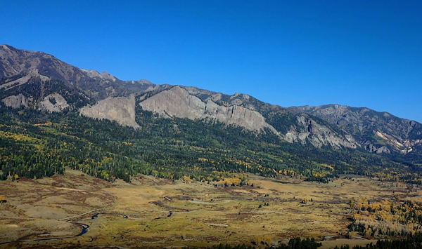 Forest landscape with scenic mountains and clear blue sky