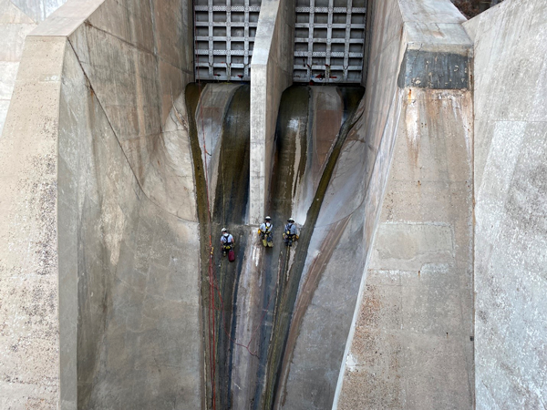 From Left: Brent Davis (BOR Heavy Duty Laborer at Flaming Gorge Dam), Nick Bennett (Central Utah Conservancy District), and Jerry Tensfield (BOR Maintenance Worker at Navajo Dam) descending from spillway gates to inspect and correct problems found with the concrete.