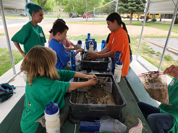 Earth Connection campers at the Ophir Canyon Educational Center camp work on building their earthen dam.