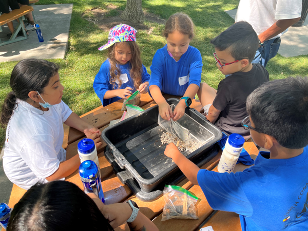 Earth Connection campers at the Thanksgiving Point camp work on building their earthen dam