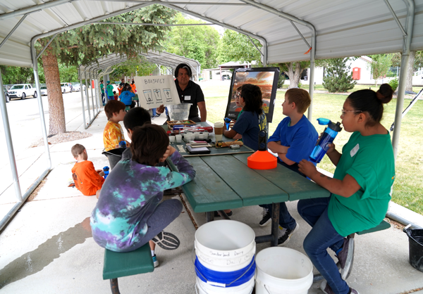 Nathaniel Todea discusses buoyancy with a group of campers